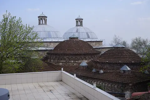 Bursa Eski Kaplıca’nın çatısında sıra sıra kiremit kubbeler ve arkada kurşun kubbeler