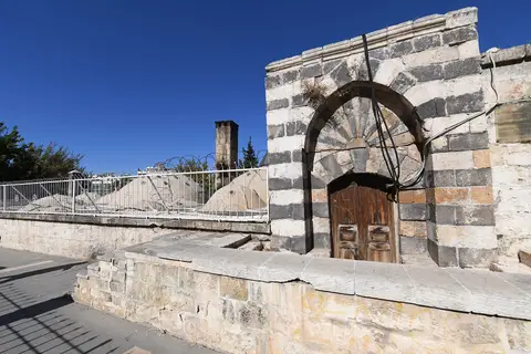 Gaziantep’teki Naib Hamamı’nın siyah-beyaz taş sıralı kemerli giriş kapısı ve ahşap kanatları