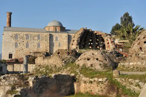 Selçuk’ta İsa Bey Hamamı’nın ışık delikli kubbe kalıntıları ve arkada İsa Bey Camii
