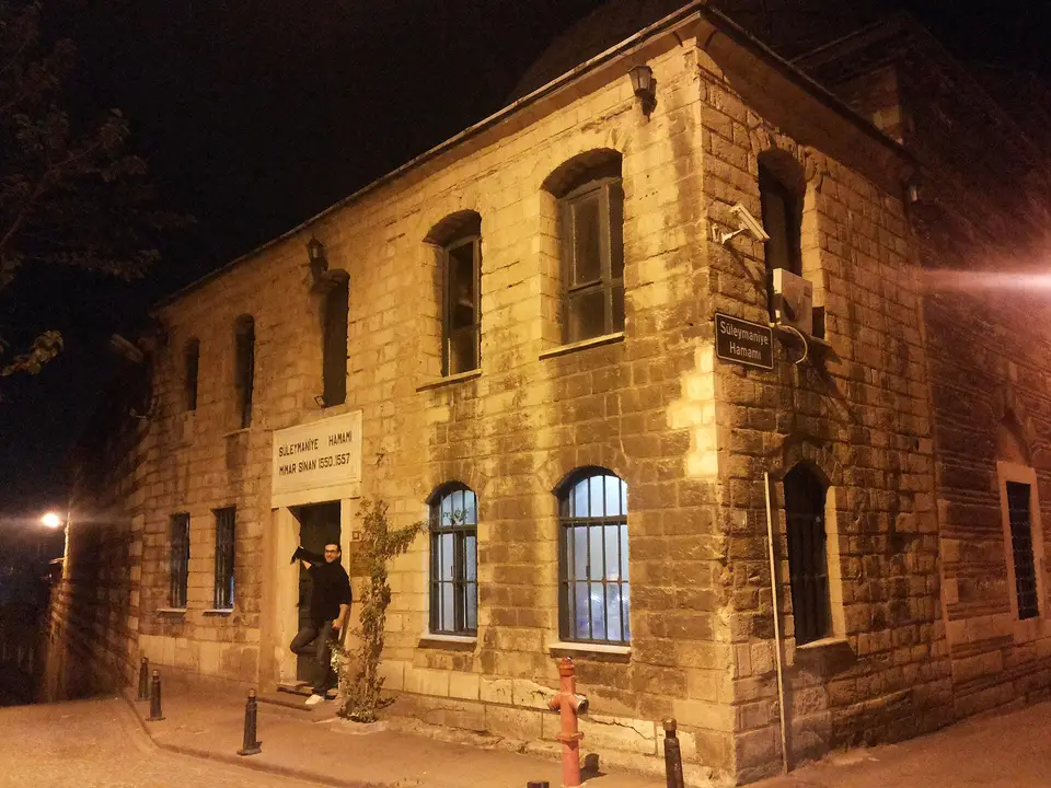 Süleymaniye Hamamı’nın gece aydınlatılmış taş cephesi ve kemerli pencereleri