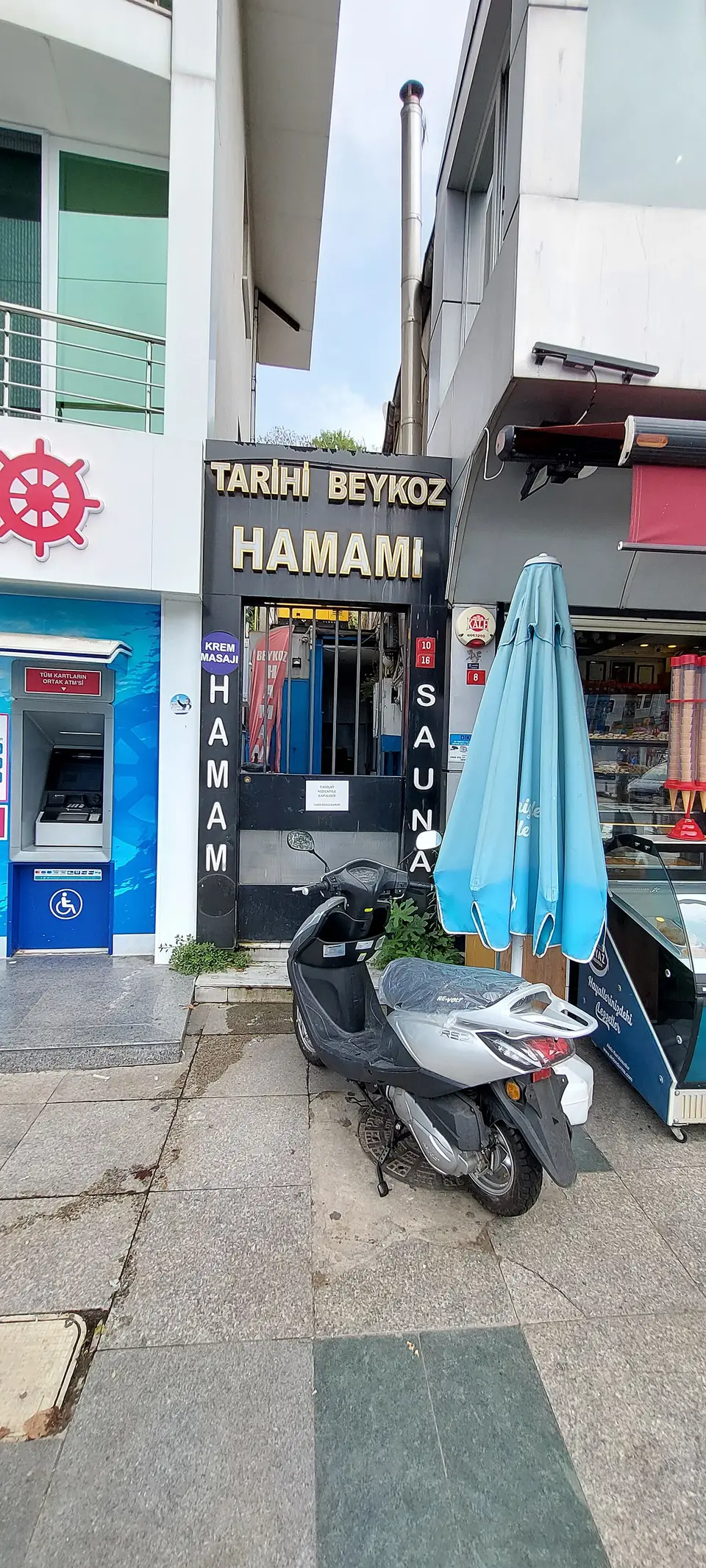 Beykoz’da Tarihi Beykoz Hamamı’nın dar sokak cephesi, girişin üstündeki tabela ve önündeki motosiklet