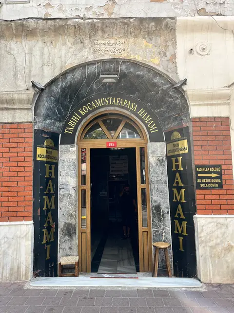 Kocamustafapaşa Hamamı’nın mermer çerçeveli kemerli girişi ve iki yanındaki dikey “Hamam” yazıları, Fatih