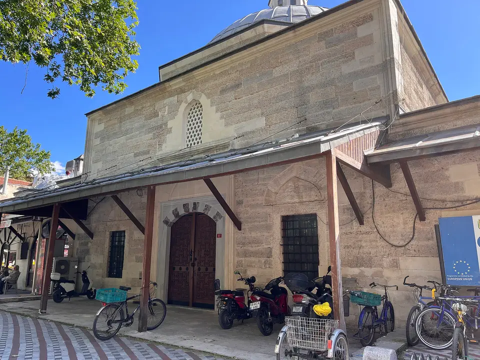 Lüleburgaz’da Sokullu Mehmet Paşa Hamamı’nın kesme taş cephesi, ahşap saçaklı giriş ve önünde bisikletler