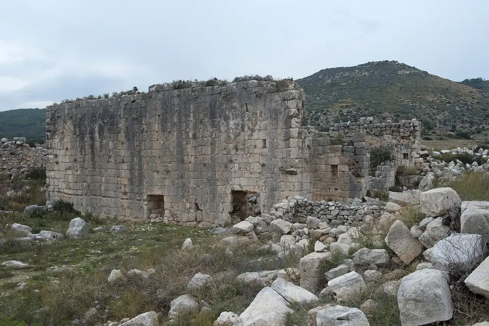 Patara antik kentinde Nero-Vespasianus hamamının yüksek taş duvarları ve yıkıntı blokları, Kaş