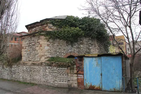 Nevşehir’de Rum Hamamı’nın otlanmış kubbesi, taş duvarları ve önündeki mavi sac kapı